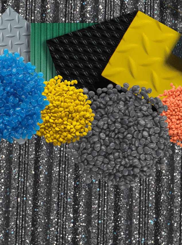 Piles of blue, yellow, grey, orange, and white plastic pellets arranged in front of various textured metal and plastic sheets